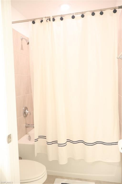 Bathroom featuring shower / tub combo and tile patterned floors