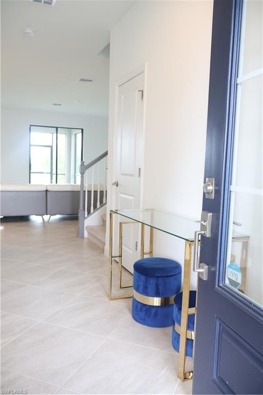 Entryway featuring light tile patterned floors and stairway