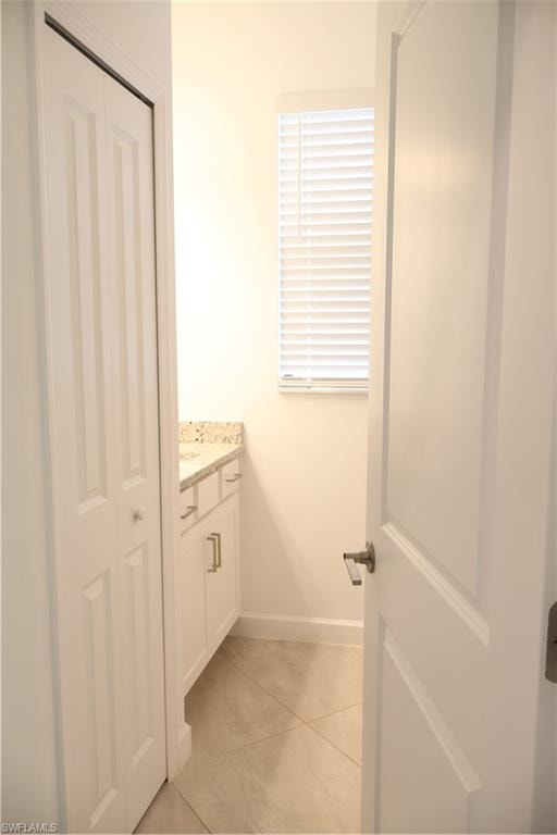 Bathroom with vanity, light tile patterned flooring, and a closet