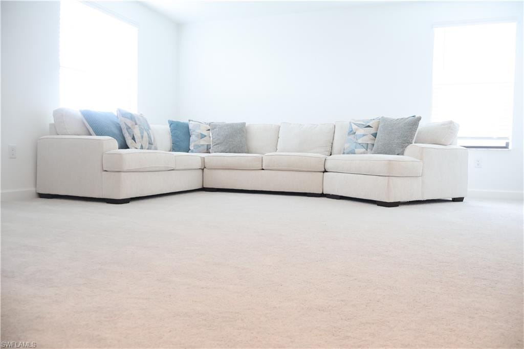 Carpeted living area featuring baseboards