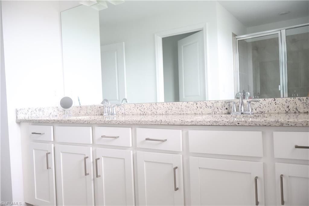 Master Bathroom with double vanity and a shower stall
