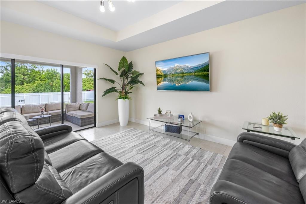 Living room with a raised ceiling and light tile patterned flooring
