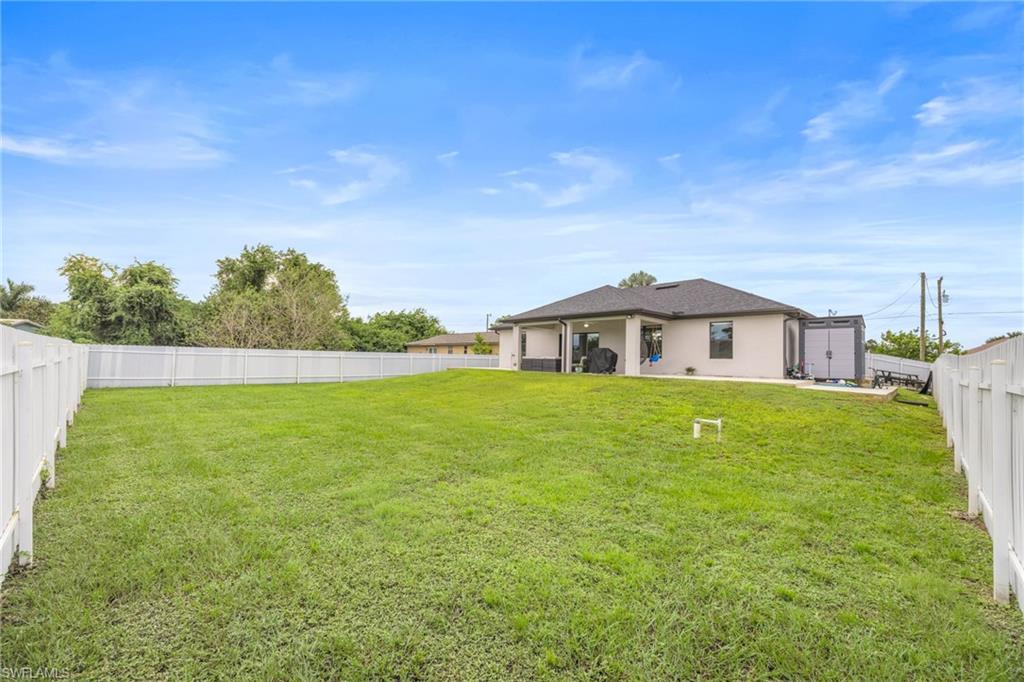 Rear view of property with a fenced backyard, a patio, and stucco siding