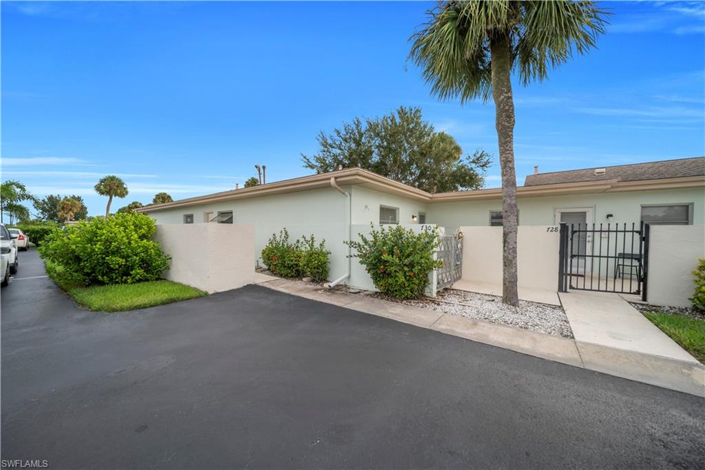 View of property exterior featuring a fenced front yard, stucco siding, and a gate