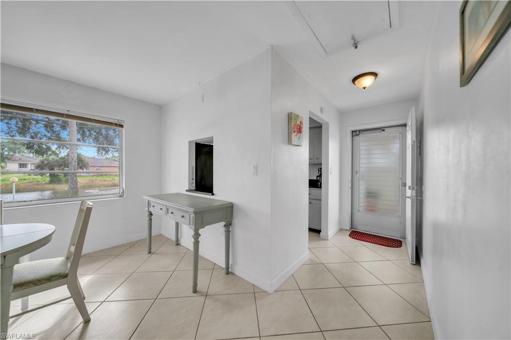 Hall featuring light tile patterned flooring and healthy amount of natural light