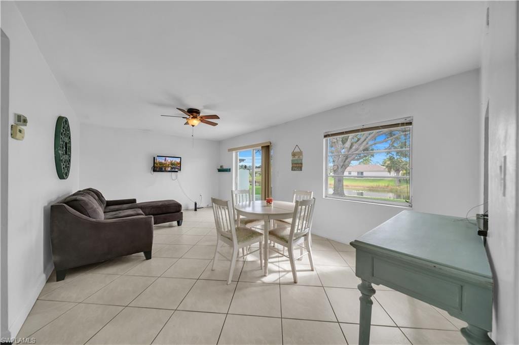 Dining space with light tile patterned floors and a ceiling fan