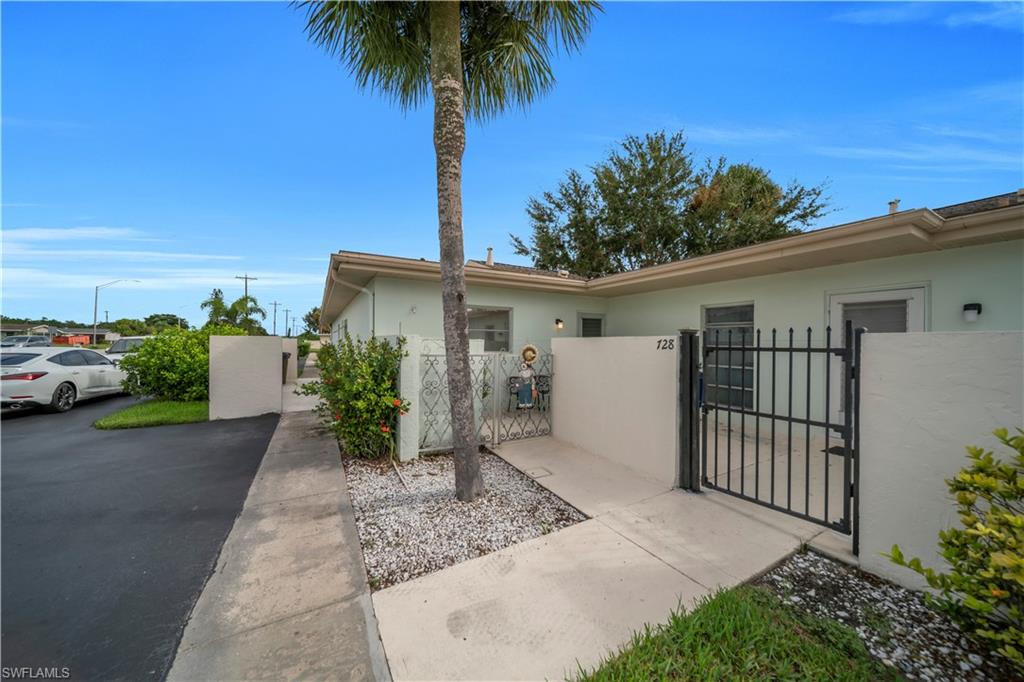 View of property exterior featuring a gate, a fenced front yard, and stucco siding
