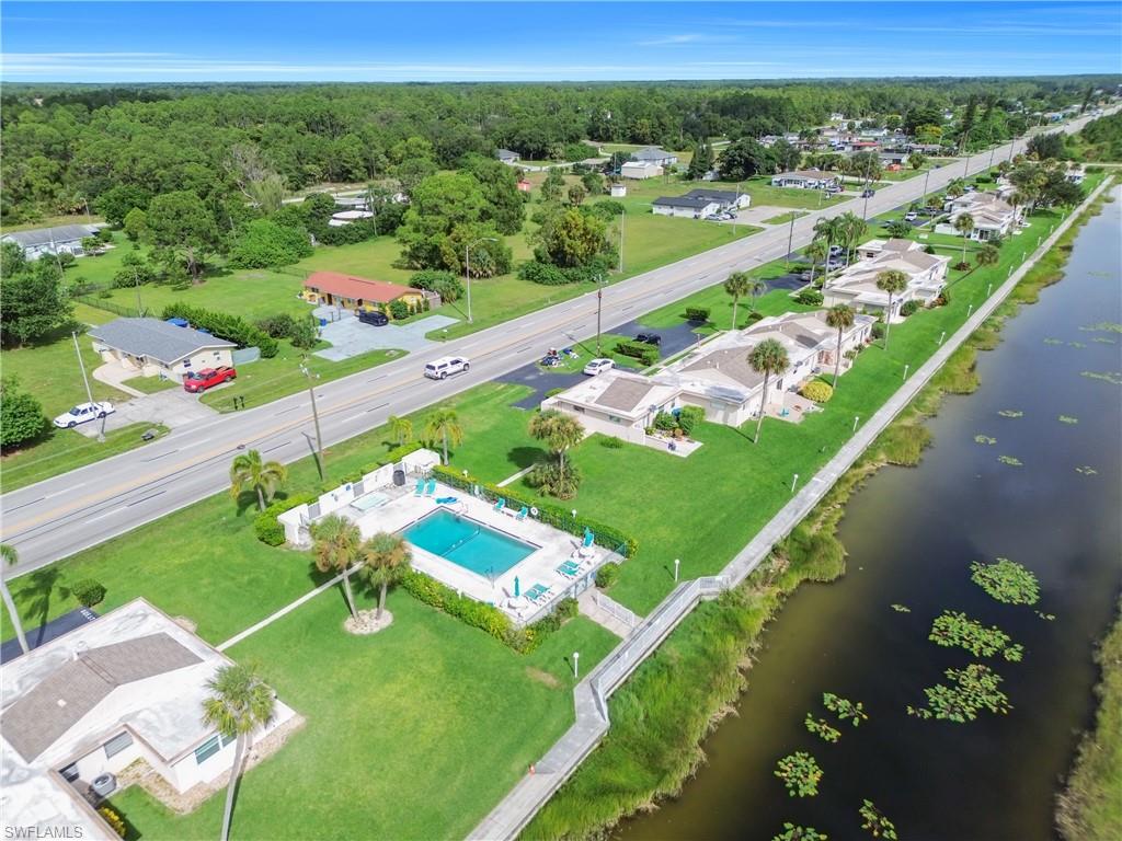 Aerial perspective of suburban area featuring a nearby body of water and a pool