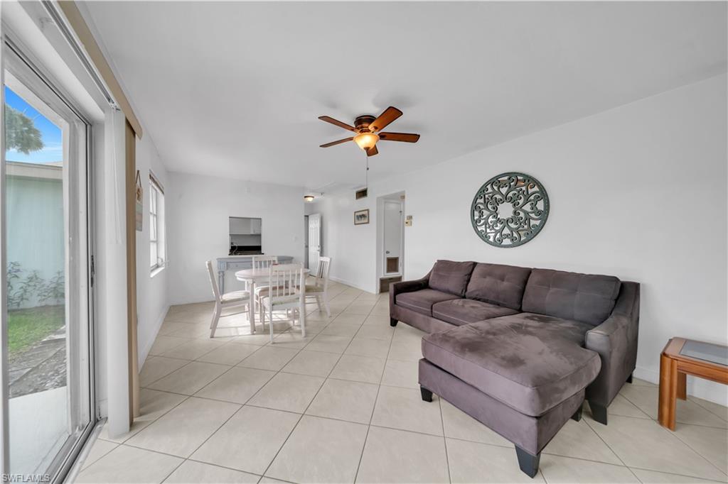 Living area with light tile patterned floors and a ceiling fan