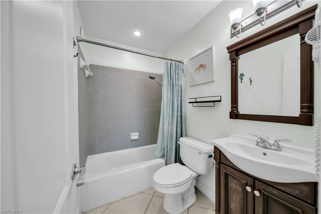 Bathroom featuring shower / tub combo, vanity, light tile patterned floors, and recessed lighting