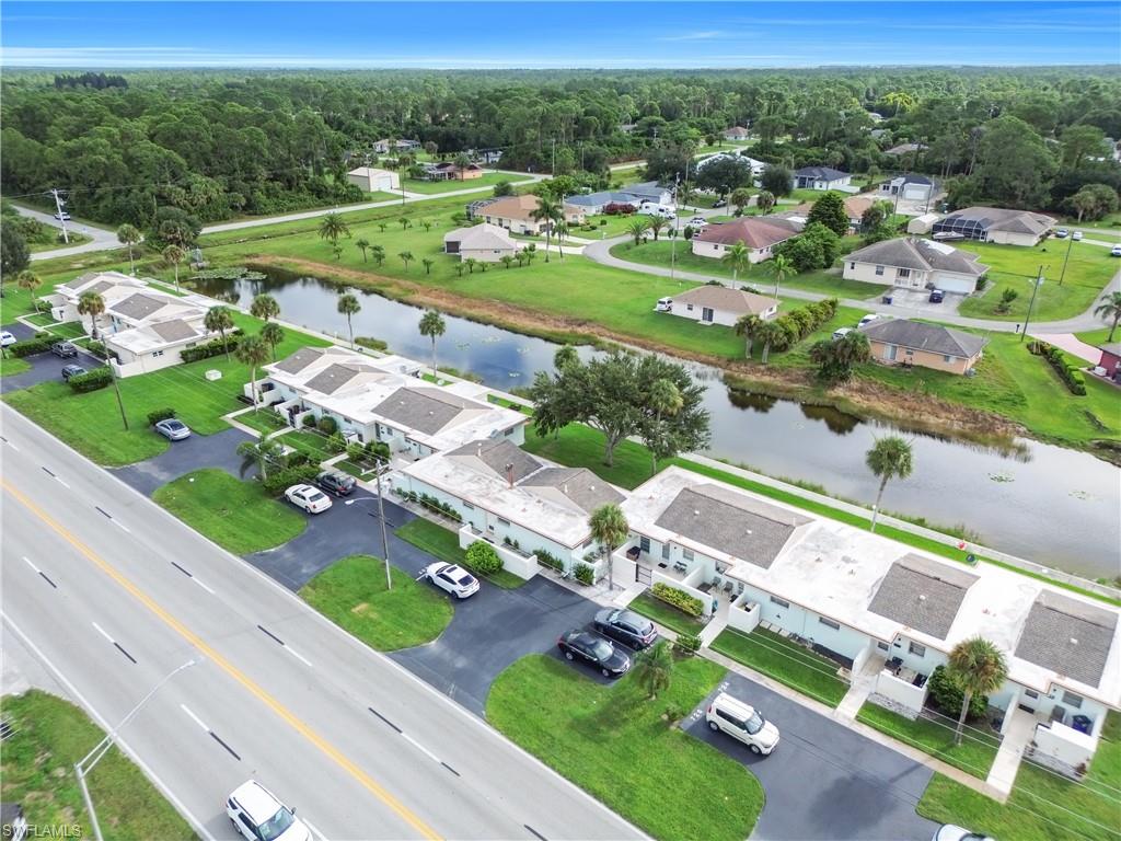Aerial view of residential area with a nearby body of water and a heavily wooded area