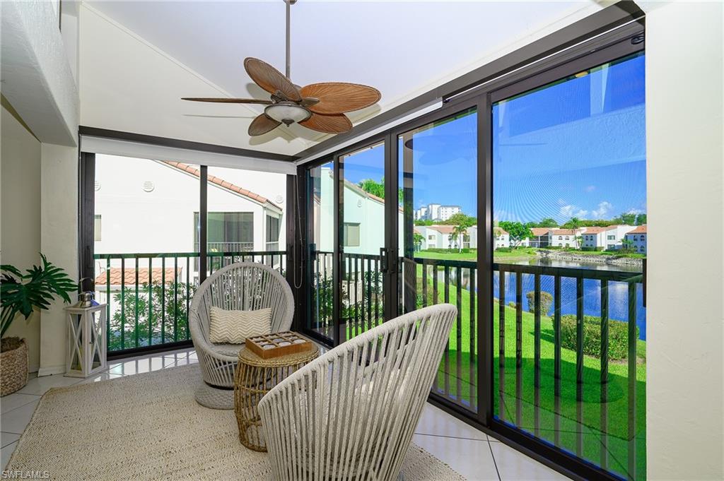 Extended living room with open lanai and lake view with water feature display, steps away from the pool and beach access gate to Vanderbilt Beach.