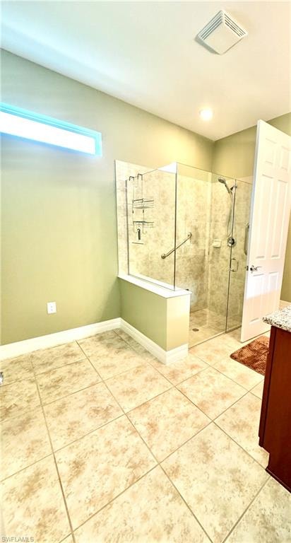 Full bathroom with a stall shower, vanity, and light tile patterned flooring