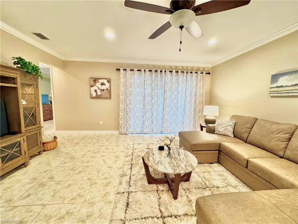 Living area with ornamental molding, tile patterned floors, a ceiling fan, and recessed lighting