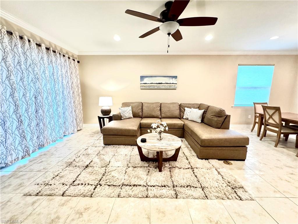 Living room with ornamental molding, recessed lighting, a ceiling fan, and light tile patterned floors