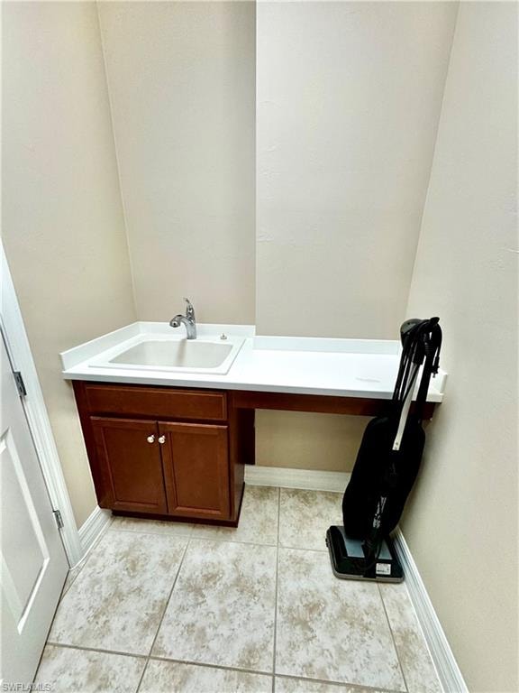 Laundry table and sink with light tile patterned flooring