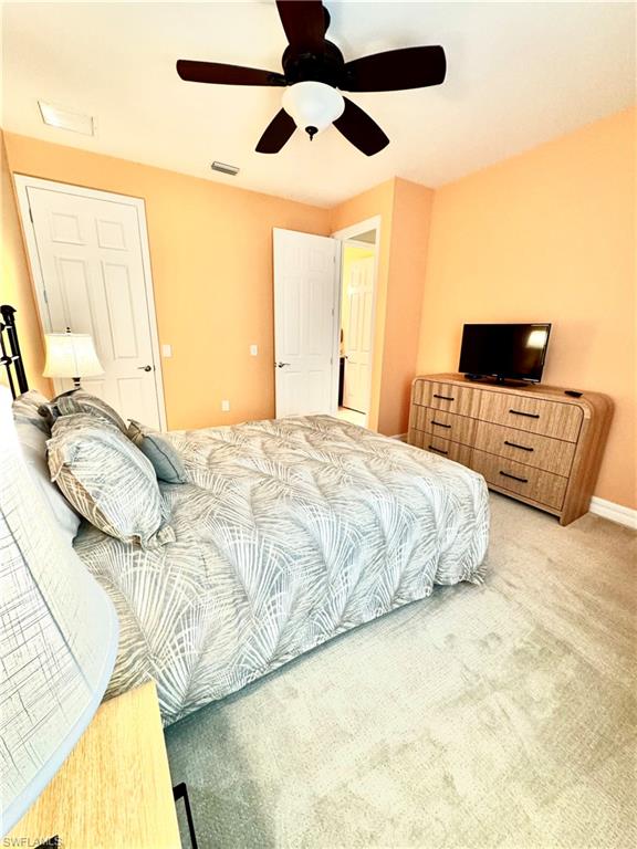 Carpeted bedroom with ceiling fan and baseboards