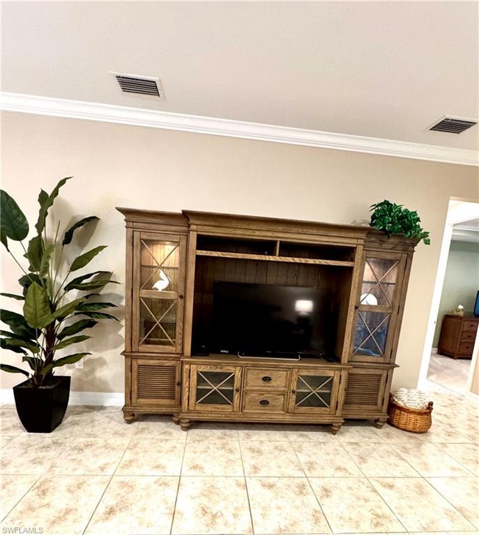 Living area with crown molding and light tile patterned floors