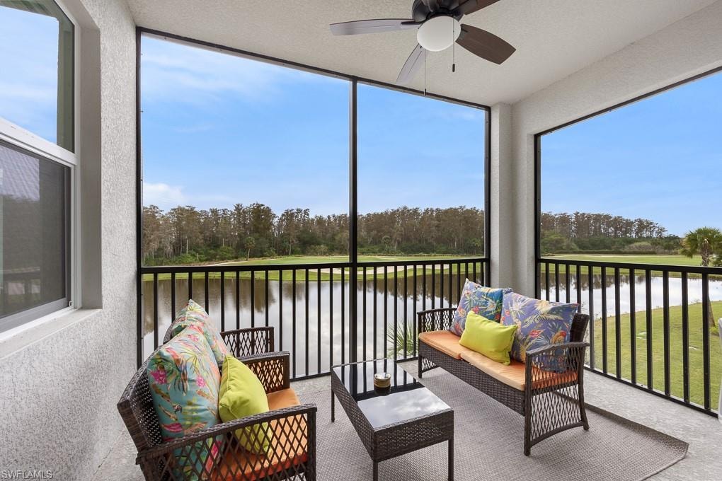 Sunroom / solarium with view of wooded area, a balcony, ceiling fan, and an outdoor hangout area
