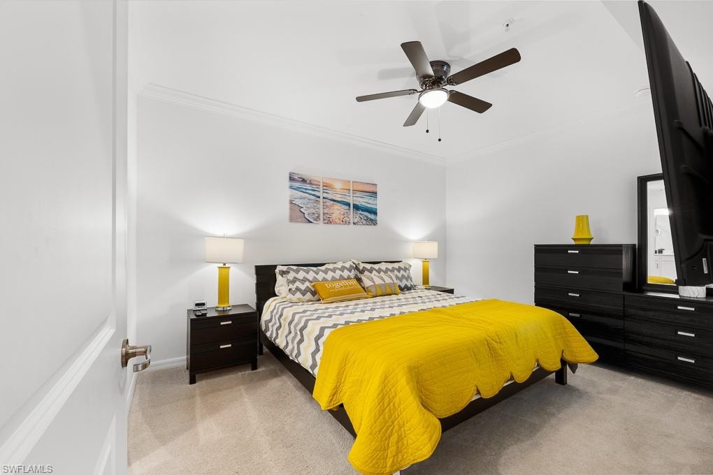 Bedroom featuring ornamental molding, light colored carpet, and ceiling fan