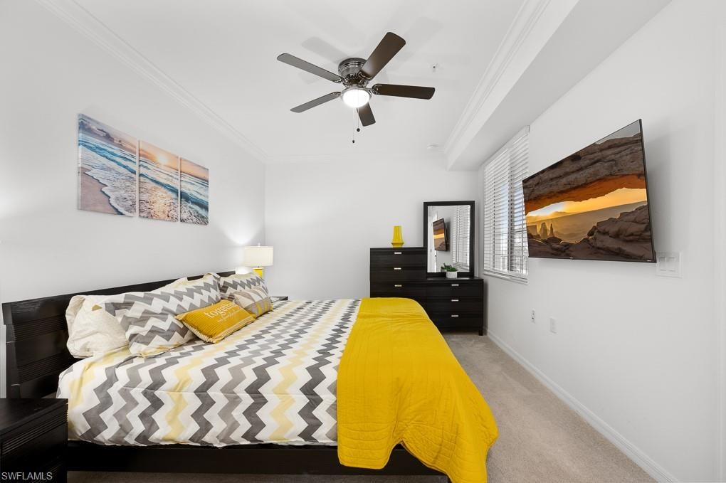 Bedroom with ornamental molding, light carpet, and a ceiling fan