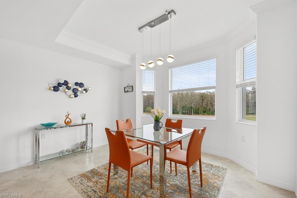 Dining space featuring ornamental molding and light tile patterned floors