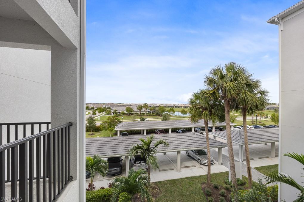 Balcony featuring the parking lot and covered parking spaces