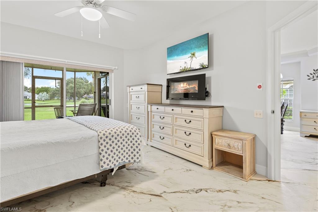 Bedroom with access to outside, light marble finish floors, and ceiling fan