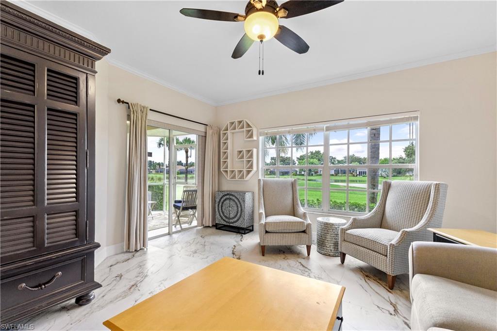 Sitting room featuring marble tiled floors, crown molding, and ceiling fan