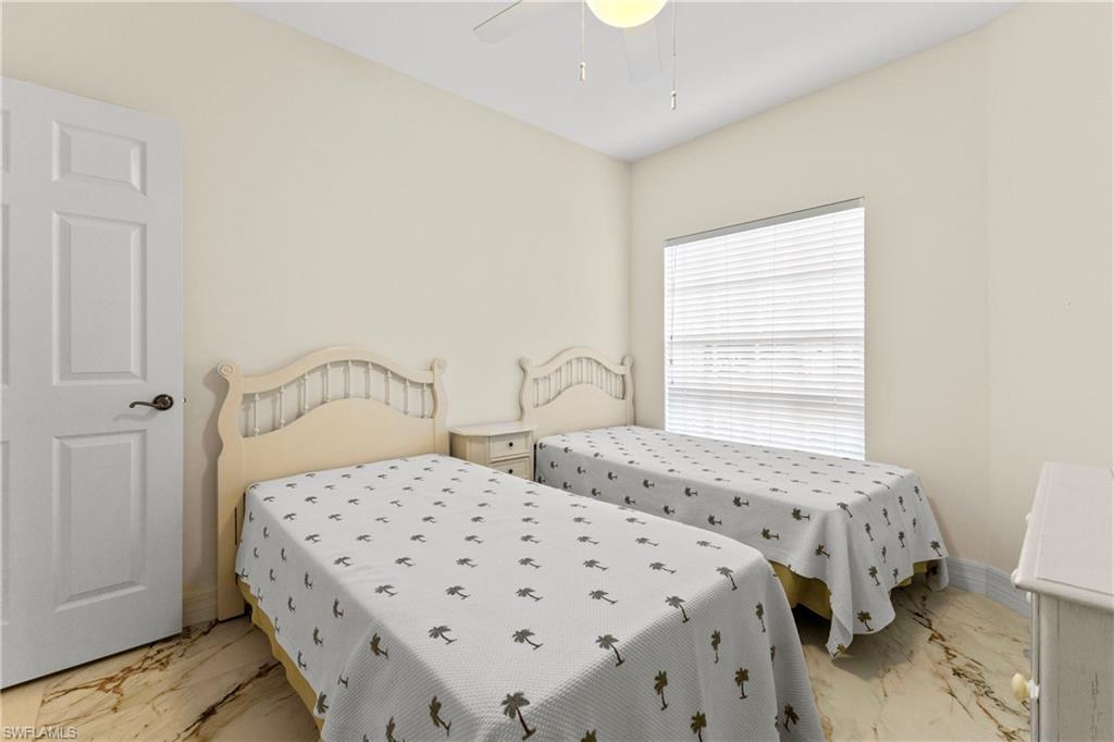 Bedroom featuring light marble finish floors and a ceiling fan