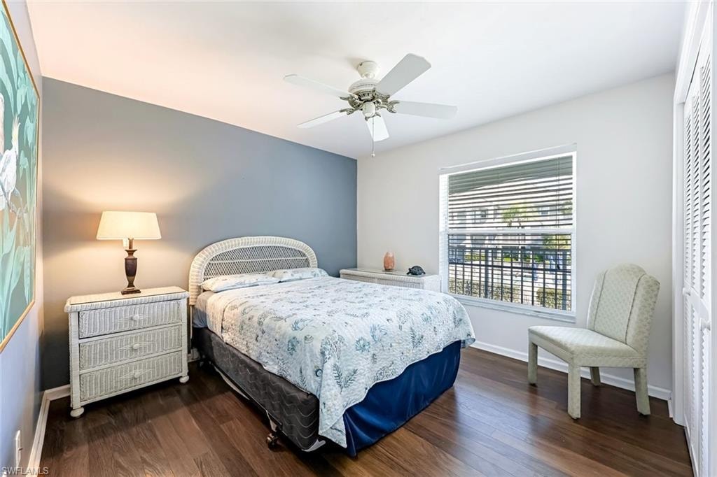 Bedroom with dark wood-style flooring, ceiling fan, and a closet