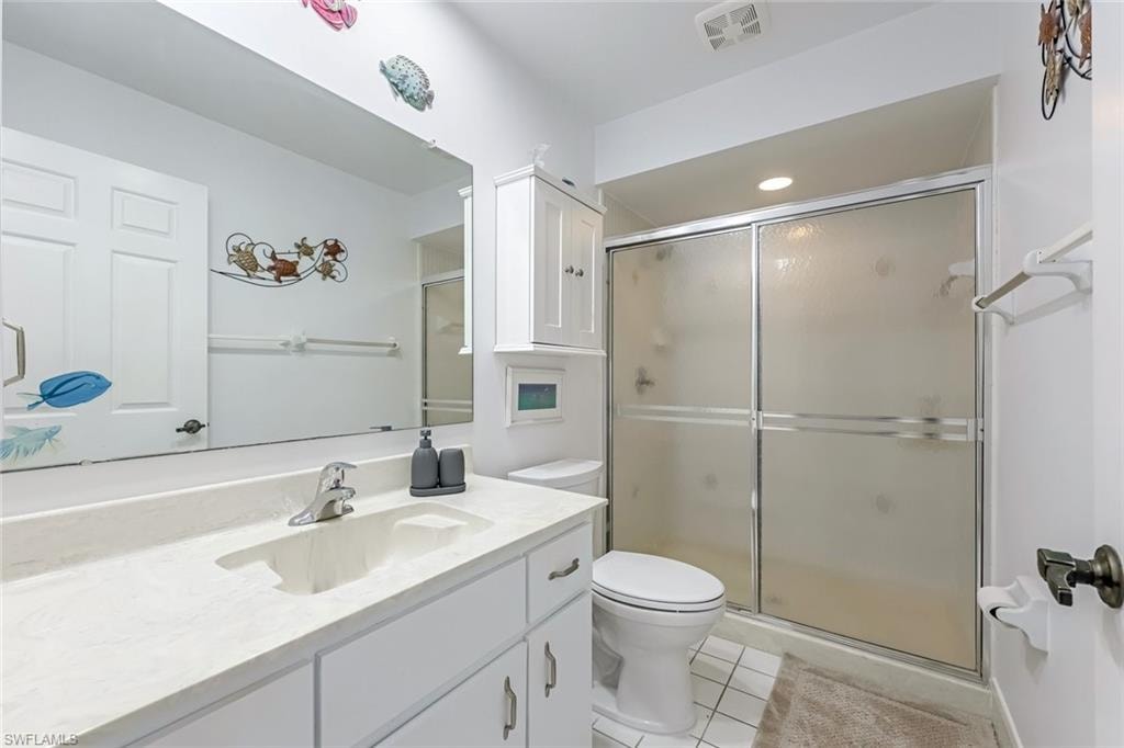 Bathroom with a shower stall, vanity, and light tile patterned floors