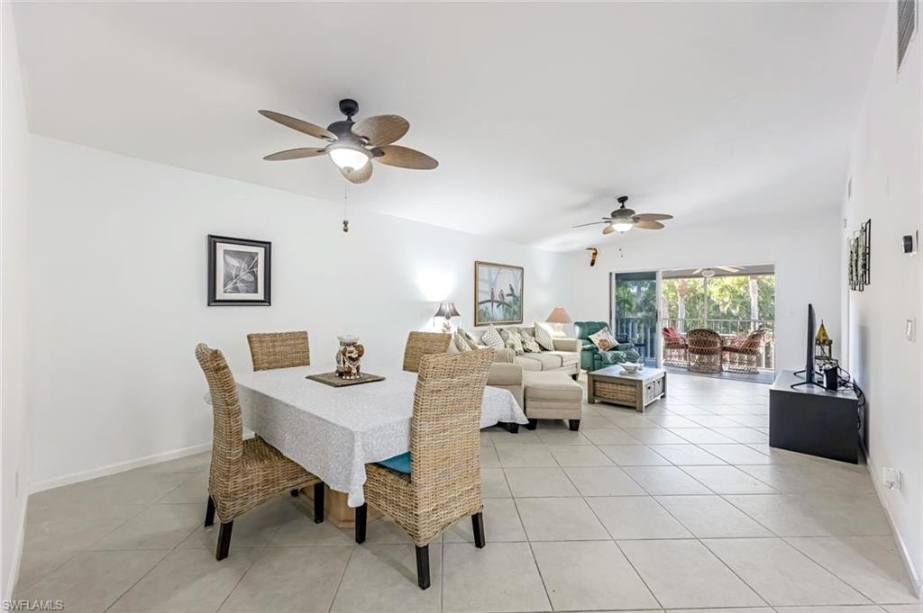 Dining space with a ceiling fan and light tile patterned floors