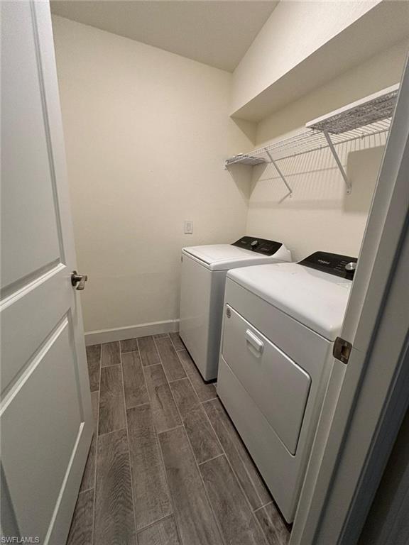 Washroom featuring wood tiled floors and washing machine and dryer