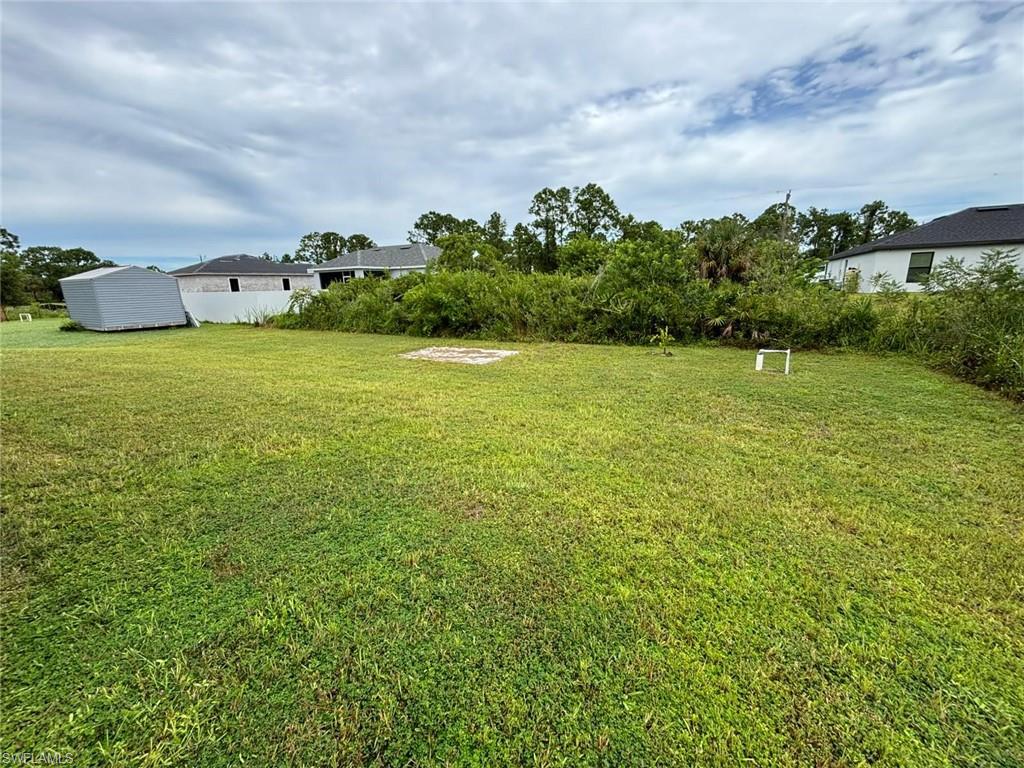 View of grassy yard with a storage shed