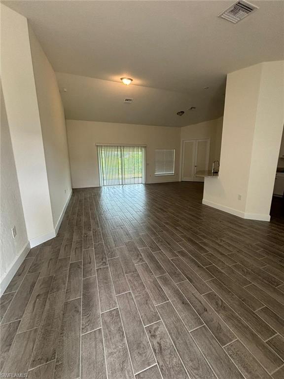 Unfurnished living room with wood finish floors and baseboards