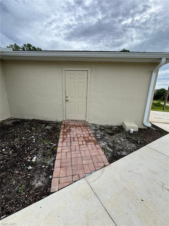 View of exterior entry featuring stucco siding