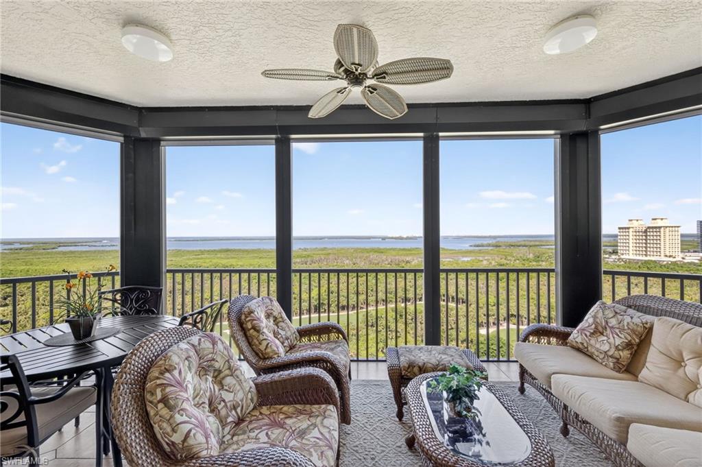 Balcony with a textured ceiling, a water view, and tile patterned floors