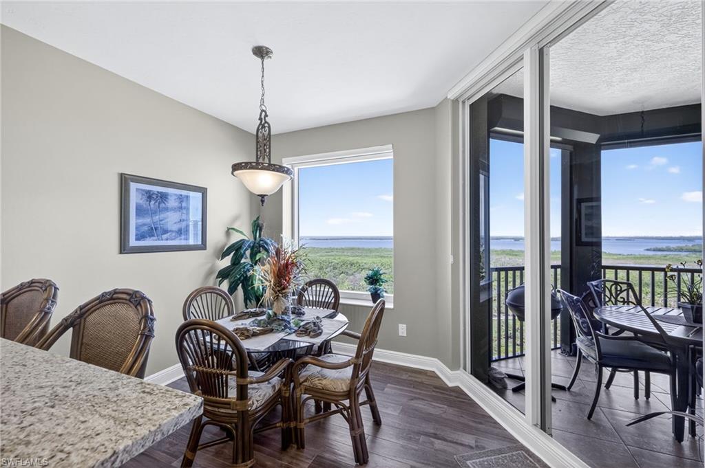 Dining area with dark wood-style floors and a water view