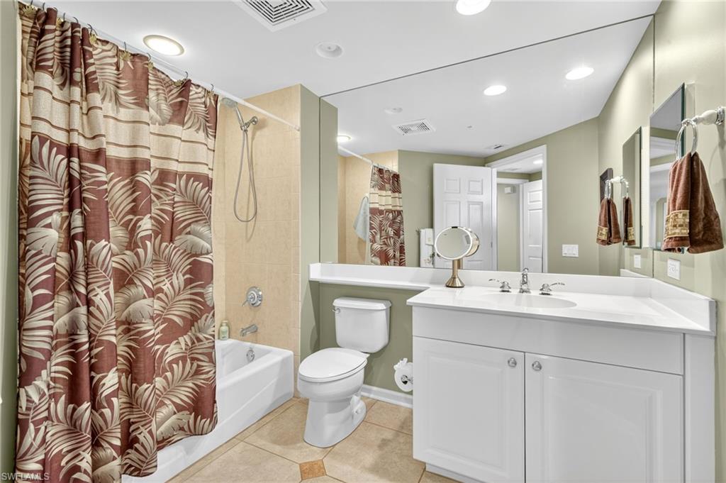 Bathroom with light tile patterned floors, shower / bath combo, vanity, and recessed lighting