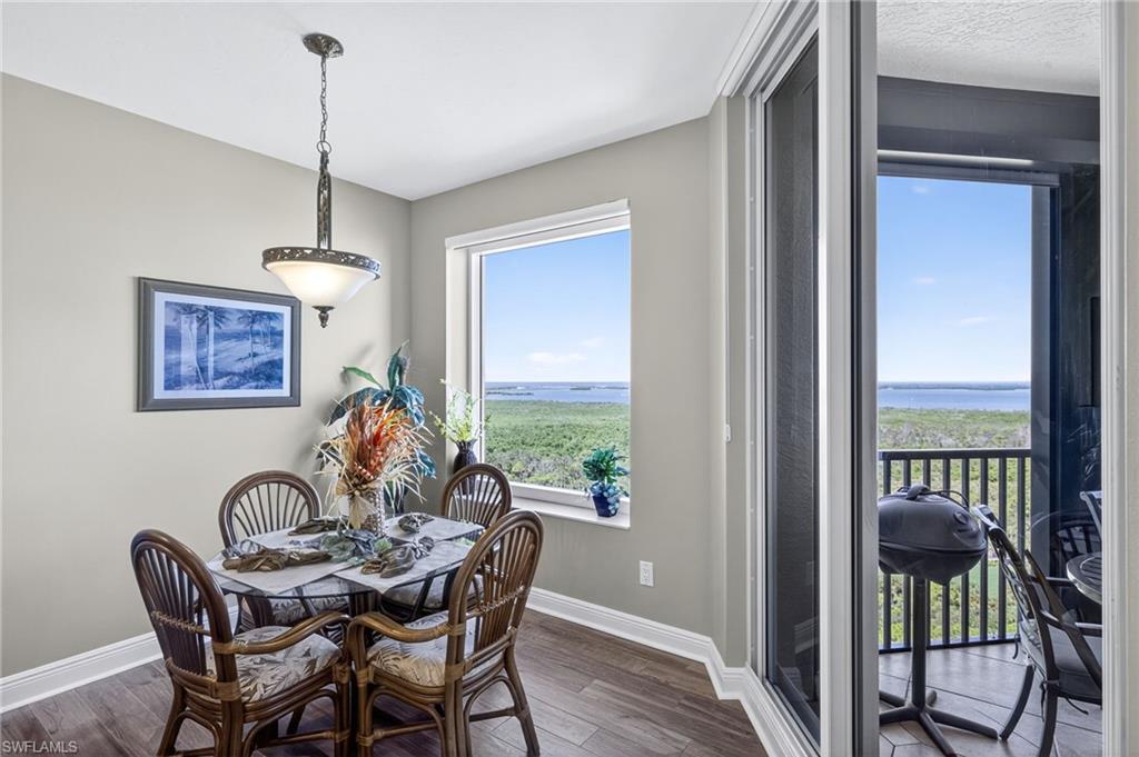 Dining room with dark wood finished floors and a water view