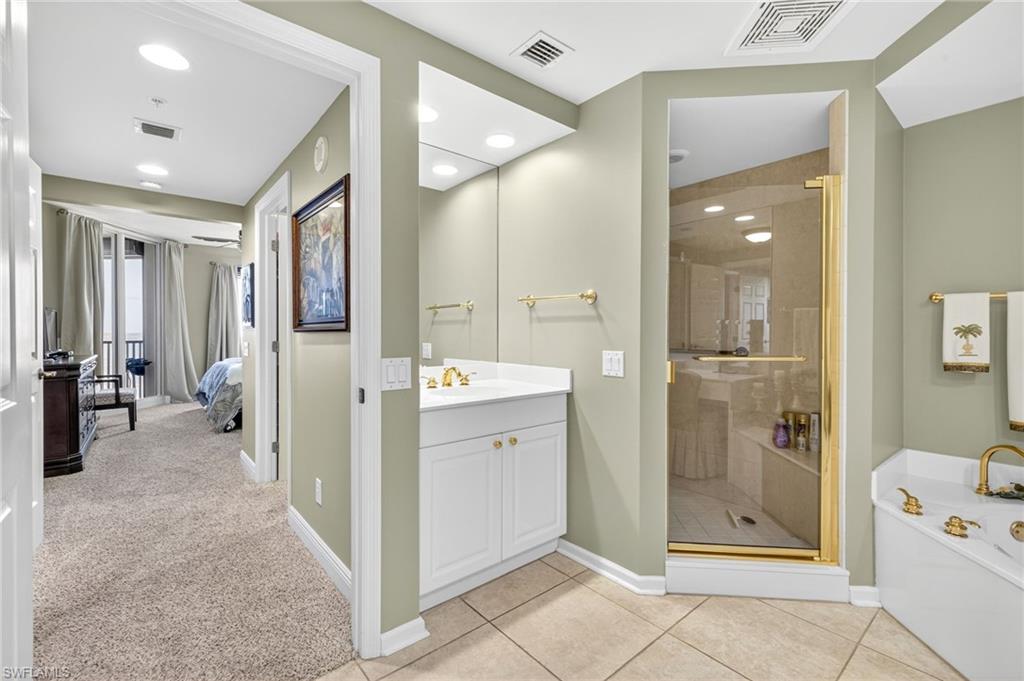 Full bathroom with vanity, a garden tub, a stall shower, ensuite bath, and light tile patterned floors