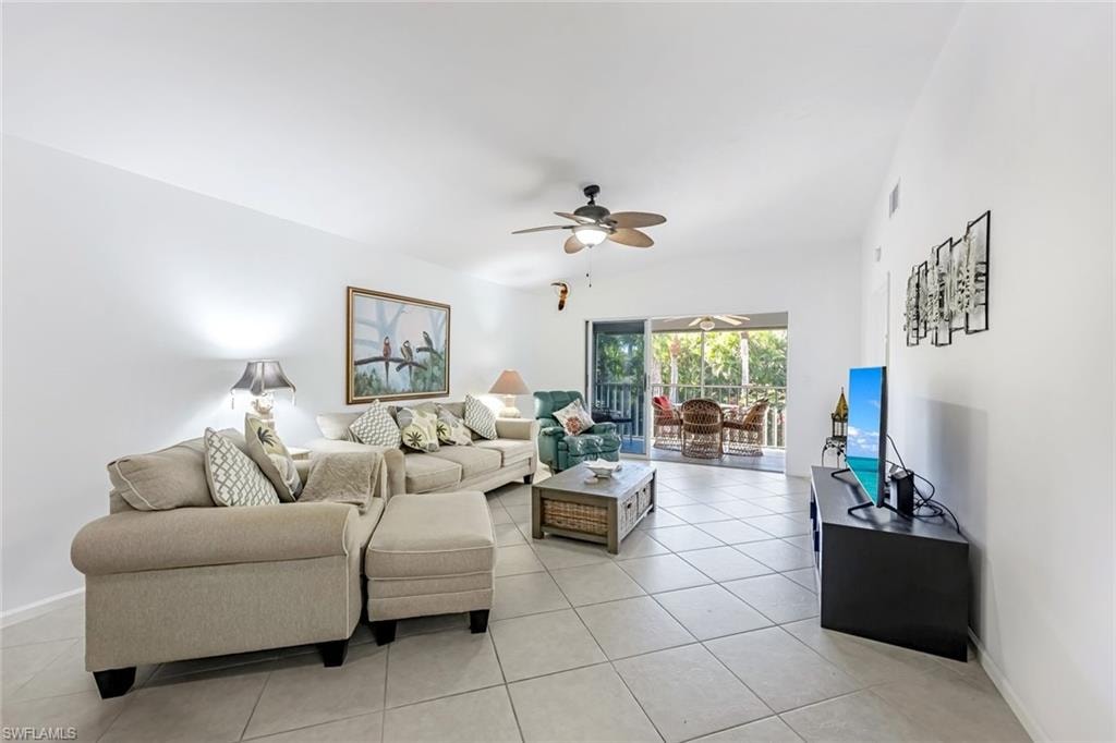 Living area with a ceiling fan and light tile patterned floors