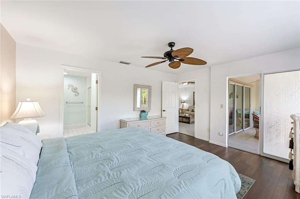 Bedroom featuring ensuite bath, dark wood finished floors, ceiling fan, and a closet