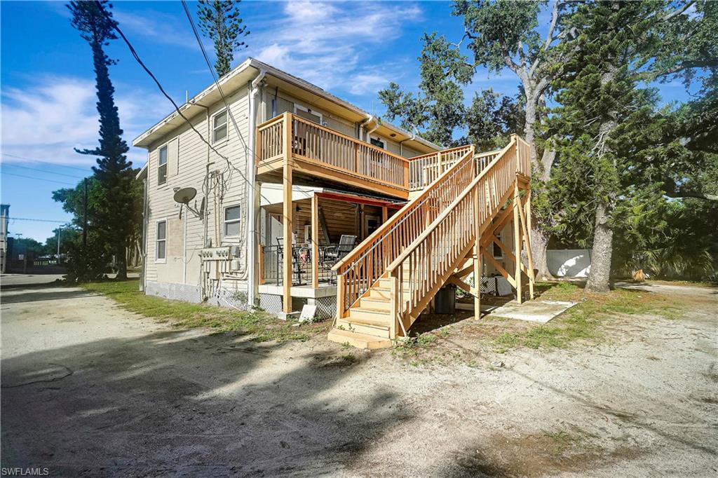 Back of property featuring a deck and stairs