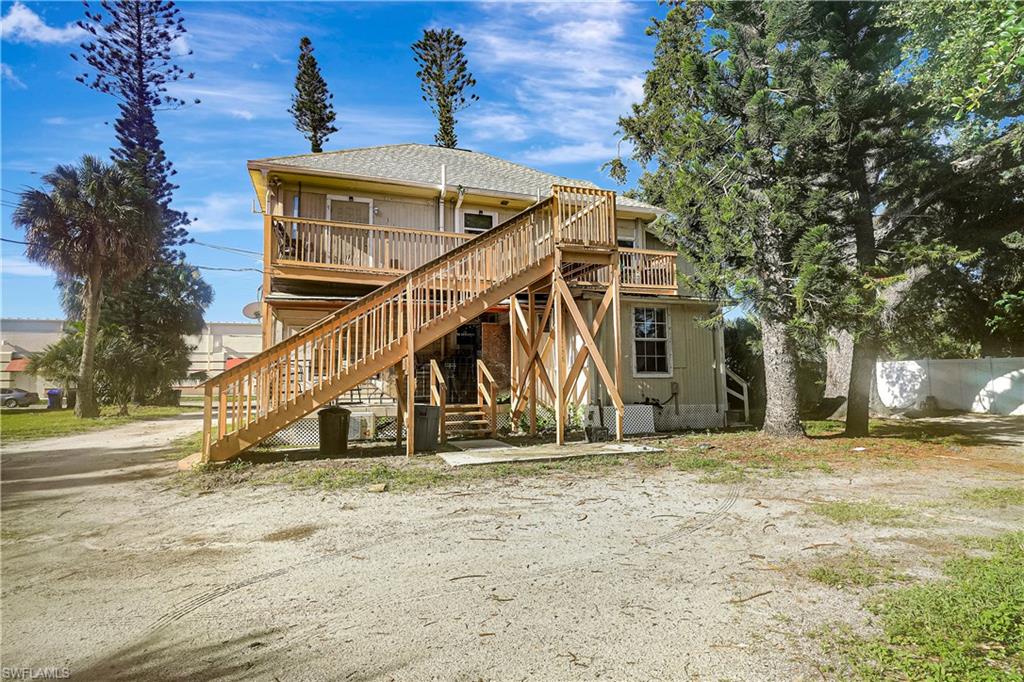 Back of property with stairs and a wooden deck