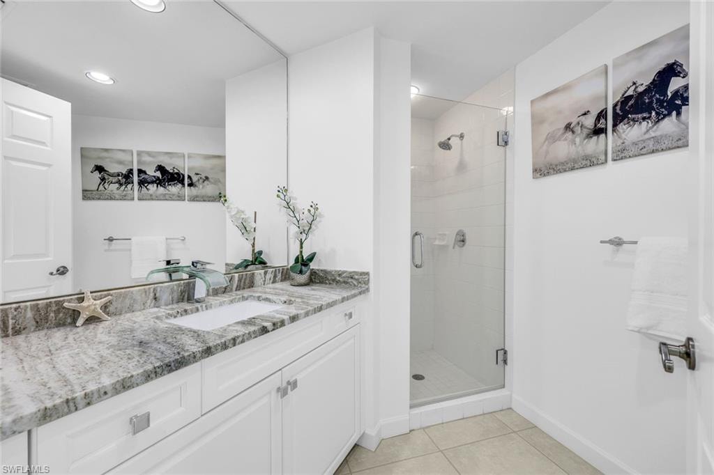 Full bathroom with vanity, a shower stall, and light tile patterned floors