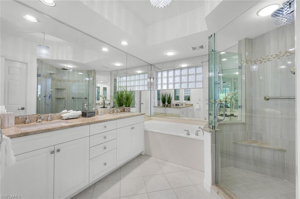 Full bathroom with a stall shower, a bath, light tile patterned flooring, double vanity, and recessed lighting