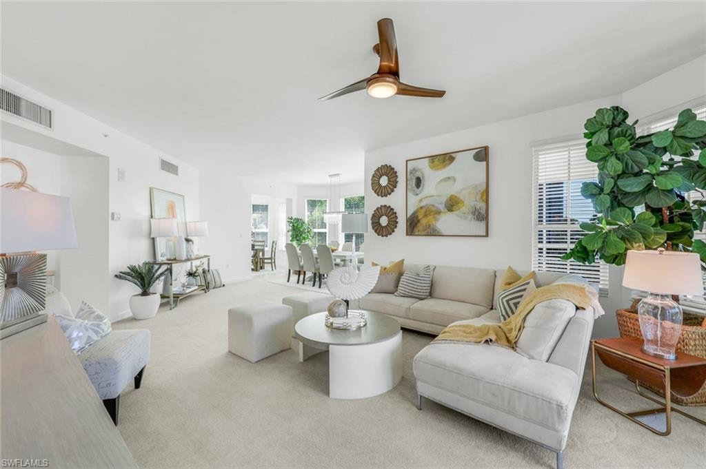 Carpeted living area featuring healthy amount of natural light and a ceiling fan