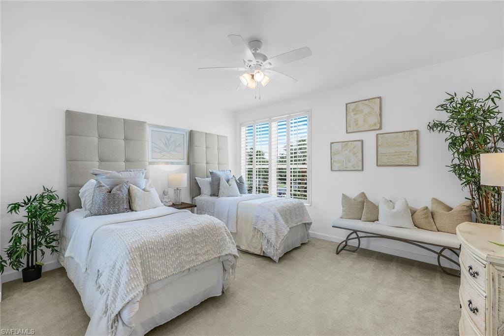 Carpeted bedroom with ceiling fan and baseboards
